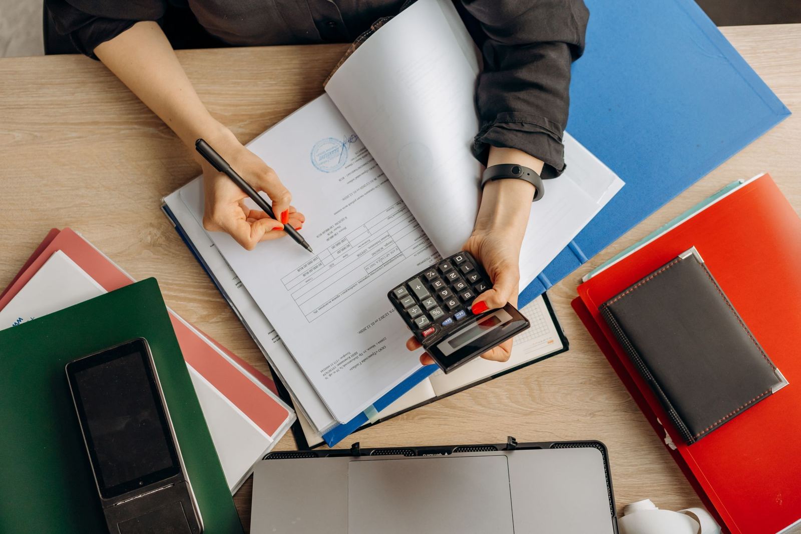 Ledgers, folders and a calculator on an accountant's desk